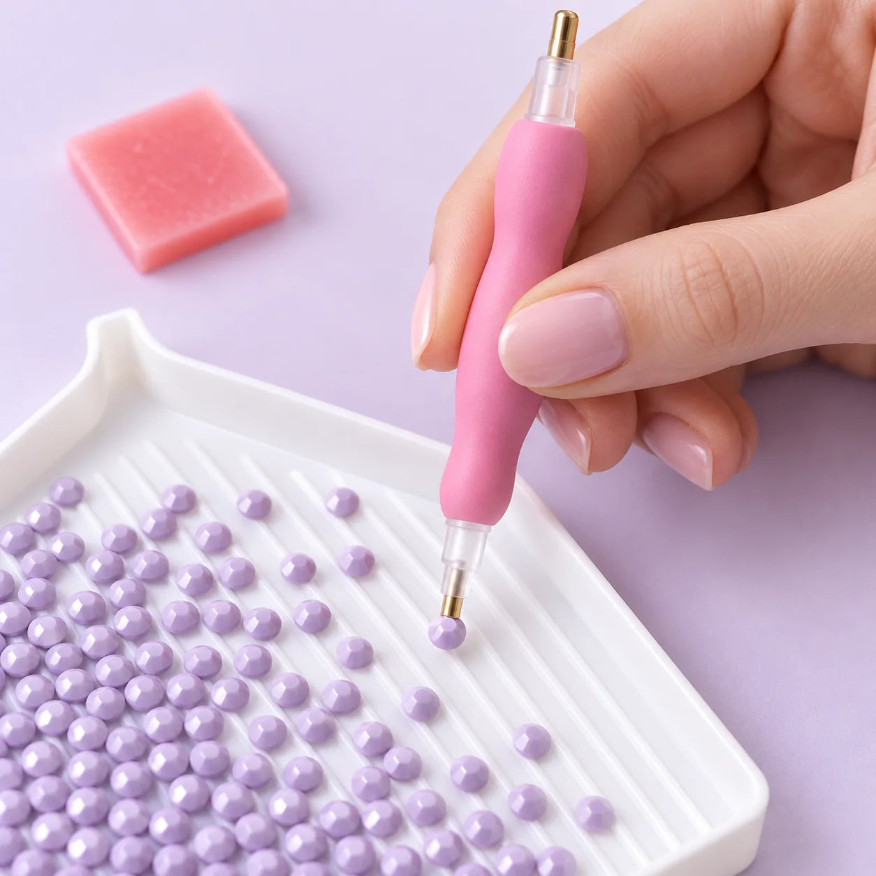 Pink applicator pen picking up a lavender resin diamond from a tray