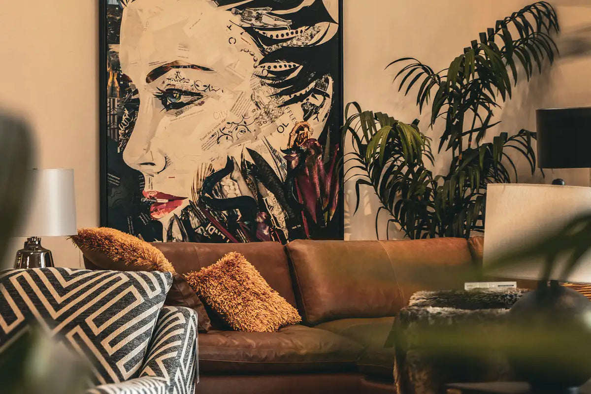 Illustrative living room with a framed woman portrait above a leather sofa, showing wall art as a room focal point.