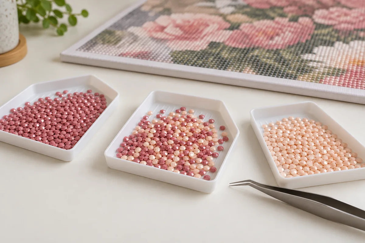 Illustrative trays separating dusty pink and peach diamond painting drills from a mixed batch