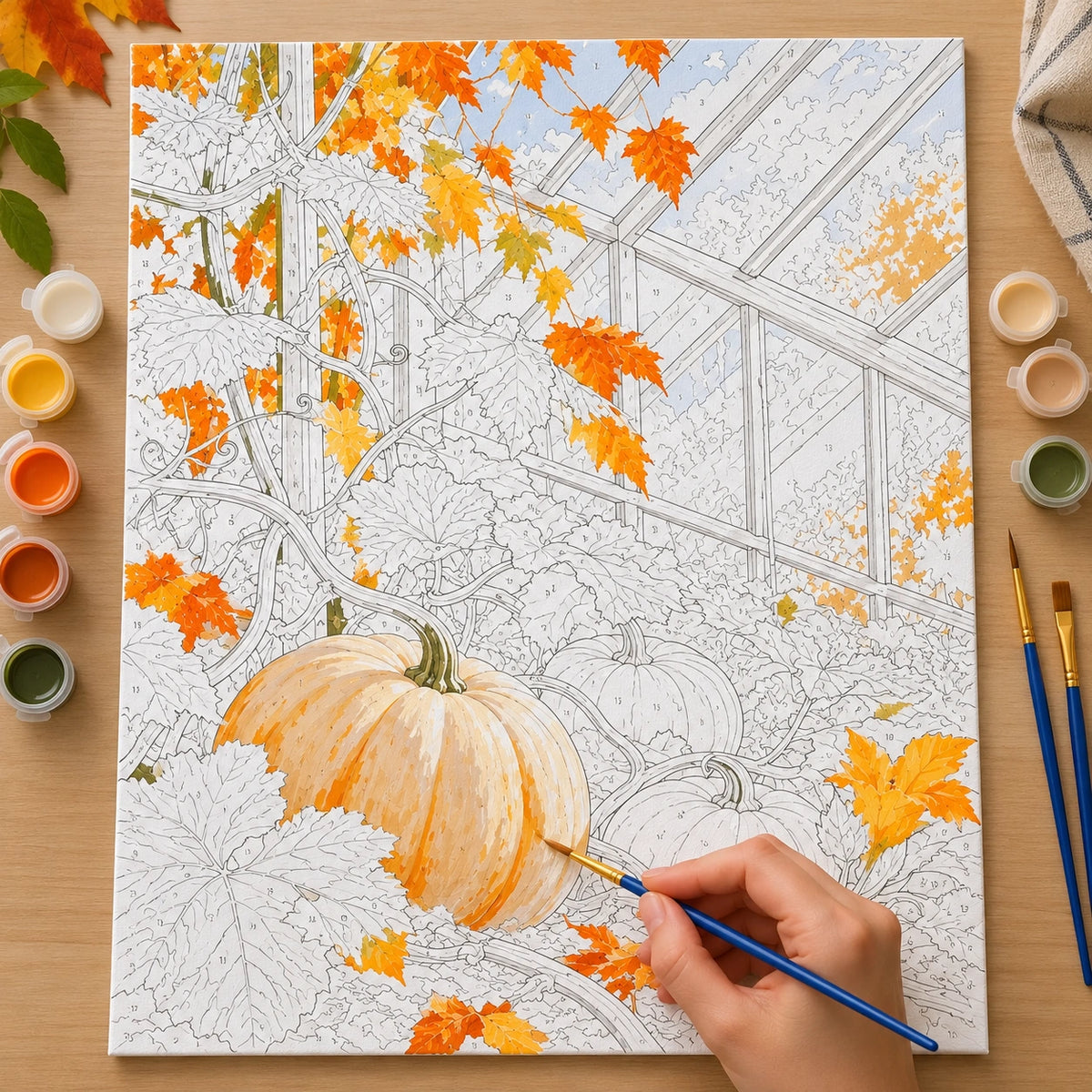 Numbered autumn greenhouse pumpkin canvas being painted with orange and cream acrylic colors.