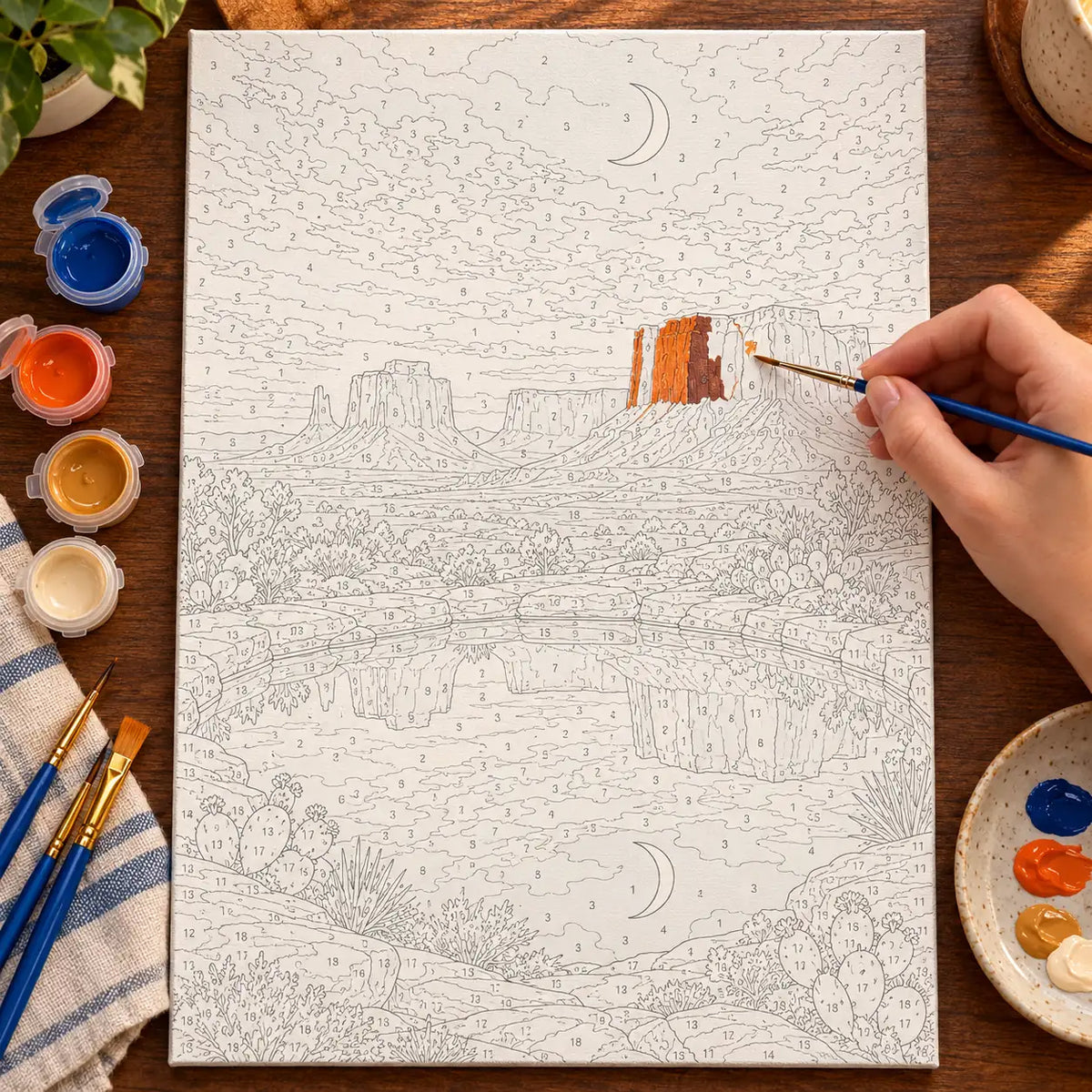 Painting process scene for the Desert Mirror Moon Pool kit, with the complete numbered canvas and painting tools.