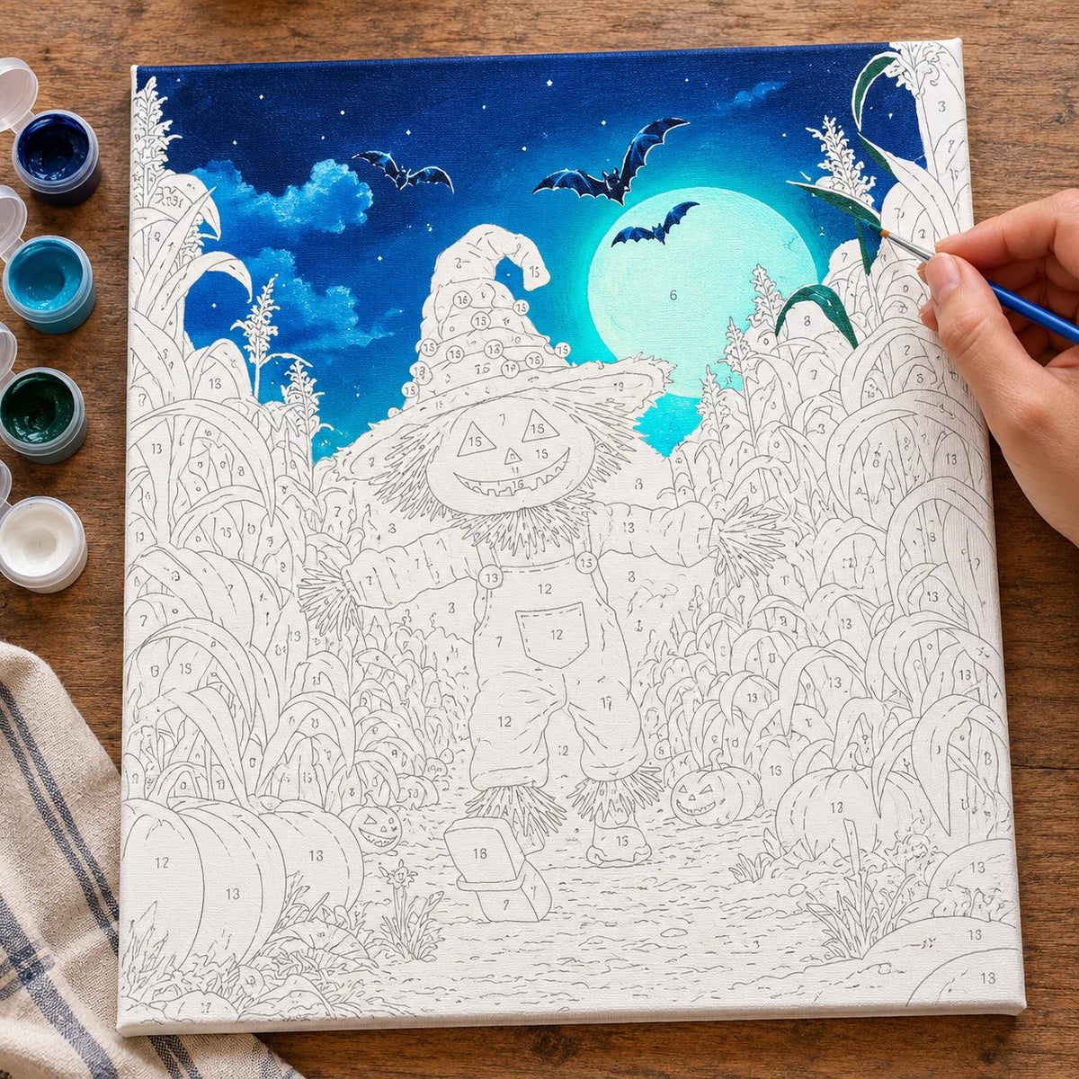 Complete Pumpkin Glow Night numbered canvas being painted with acrylic paints and brushes