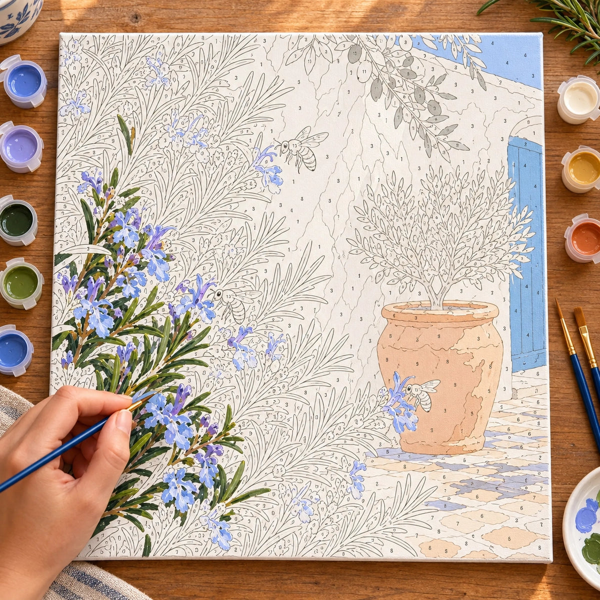 Numbered blue flower and bee canvas being painted with acrylic colors.