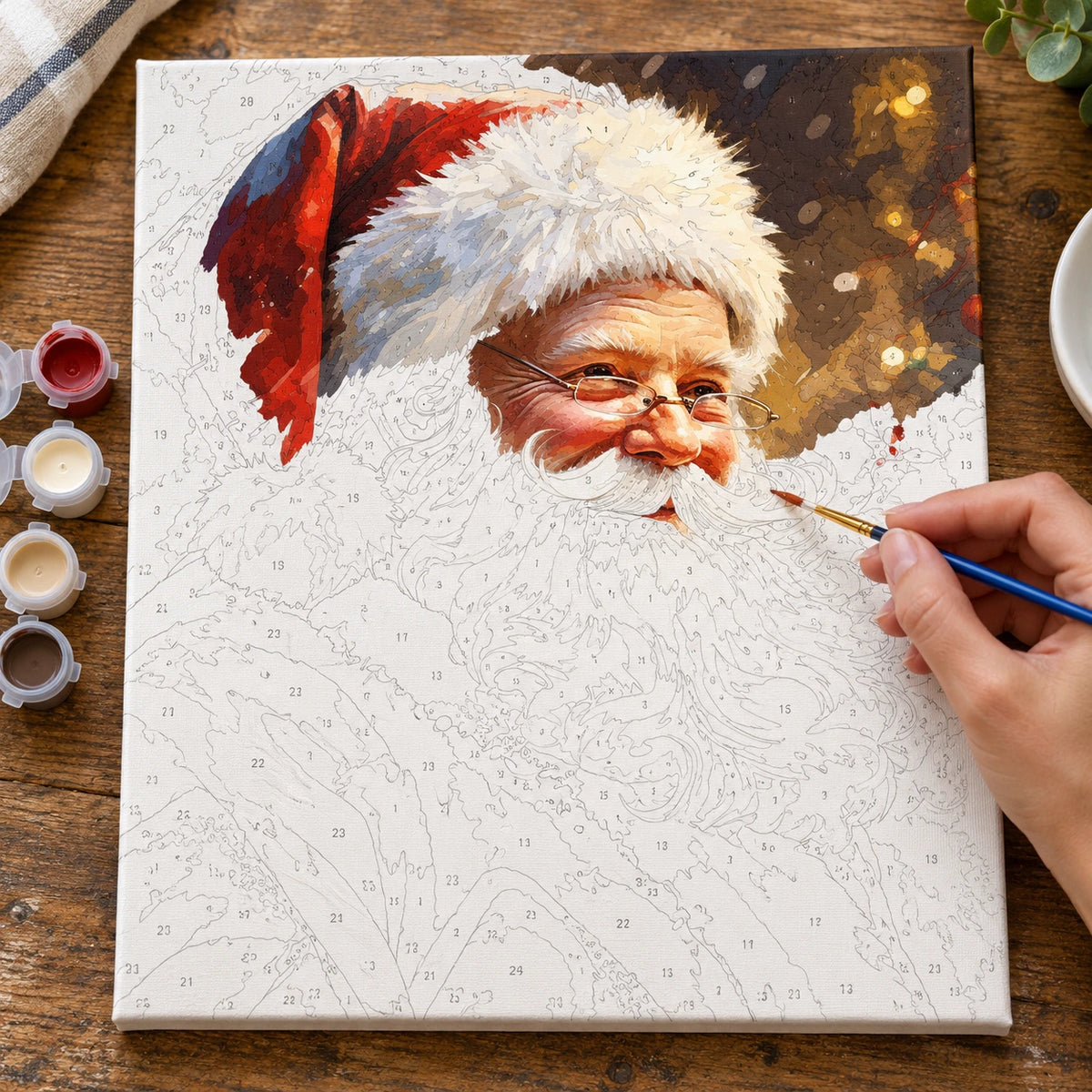 Complete Santa’s Festive Smile numbered canvas being painted with acrylic paints and brushes