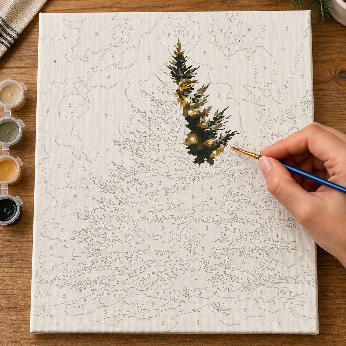 Complete Star Topped Woodland Christmas Tree numbered canvas being painted with acrylic paints and brushes