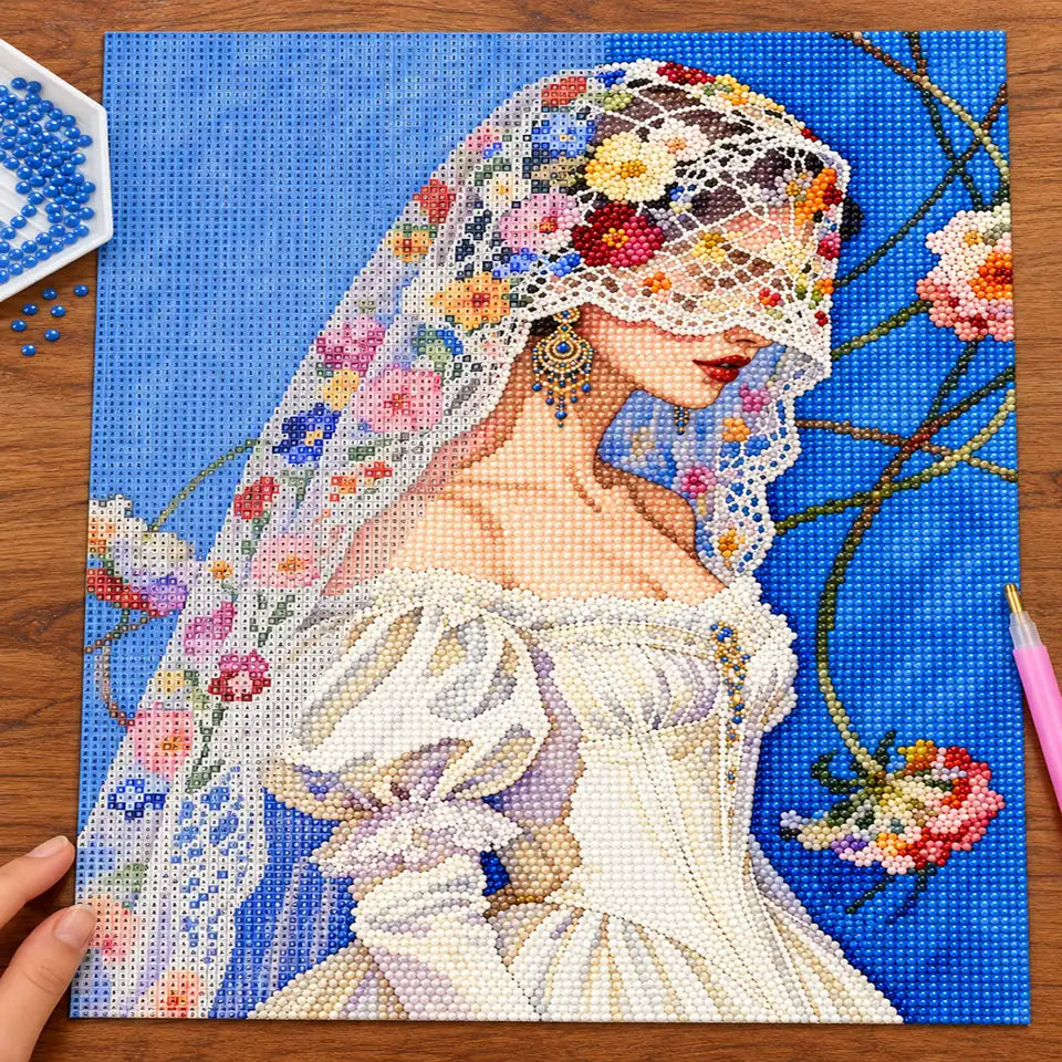 Diamond painting process showing a bride in a lace veil being completed with a stylus