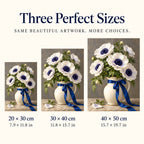 White anemones with deep navy centers and green leaves in a ceramic vase tied with a cobalt ribbon: three available size guide