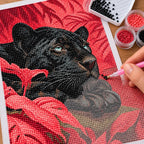 Hands applying drills to a canvas with a black panther reclining among vivid coral leaves.