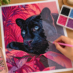 Hands applying drills to a canvas with a blue-eyed black panther surrounded by magenta foliage.