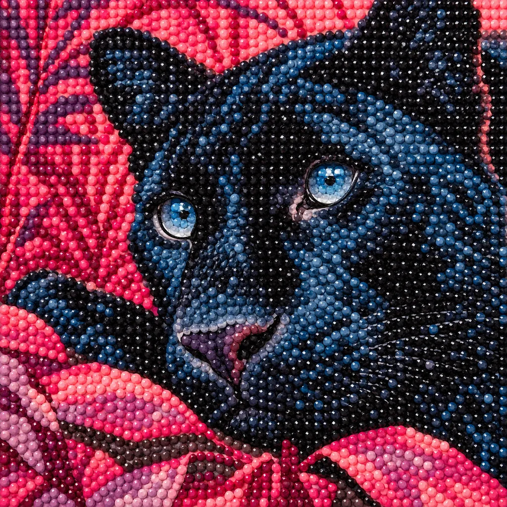 Close-up of diamond drills on artwork of a blue-eyed black panther surrounded by magenta foliage.