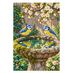 Finished diamond painting of two blue tits at a stone birdbath on a white background