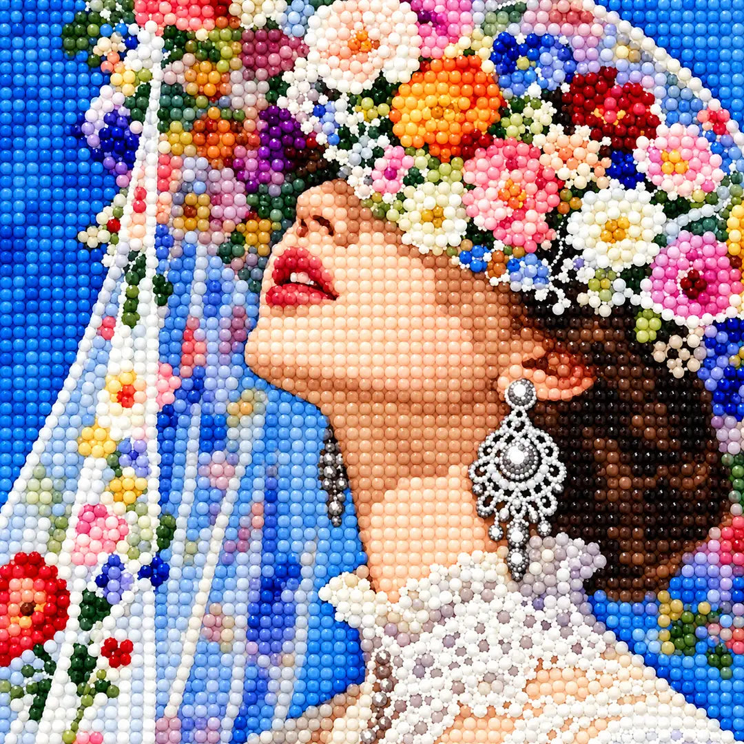Close-up diamond drill detail of the bride’s floral veil, earrings, and upward gaze