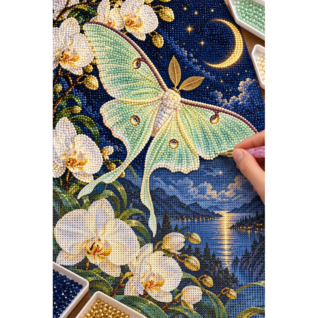 Hands applying drills to the luna moth and orchid diamond painting