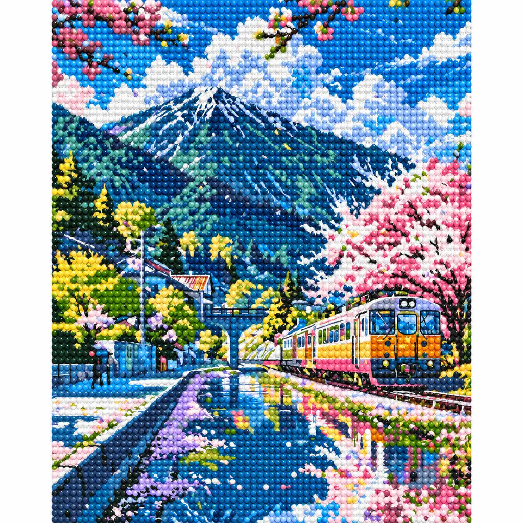 Completed Cherry Blossoms By The Tracks diamond painting showing pink cherry blossoms lining a mountain railway as a train crosses a blue stream.