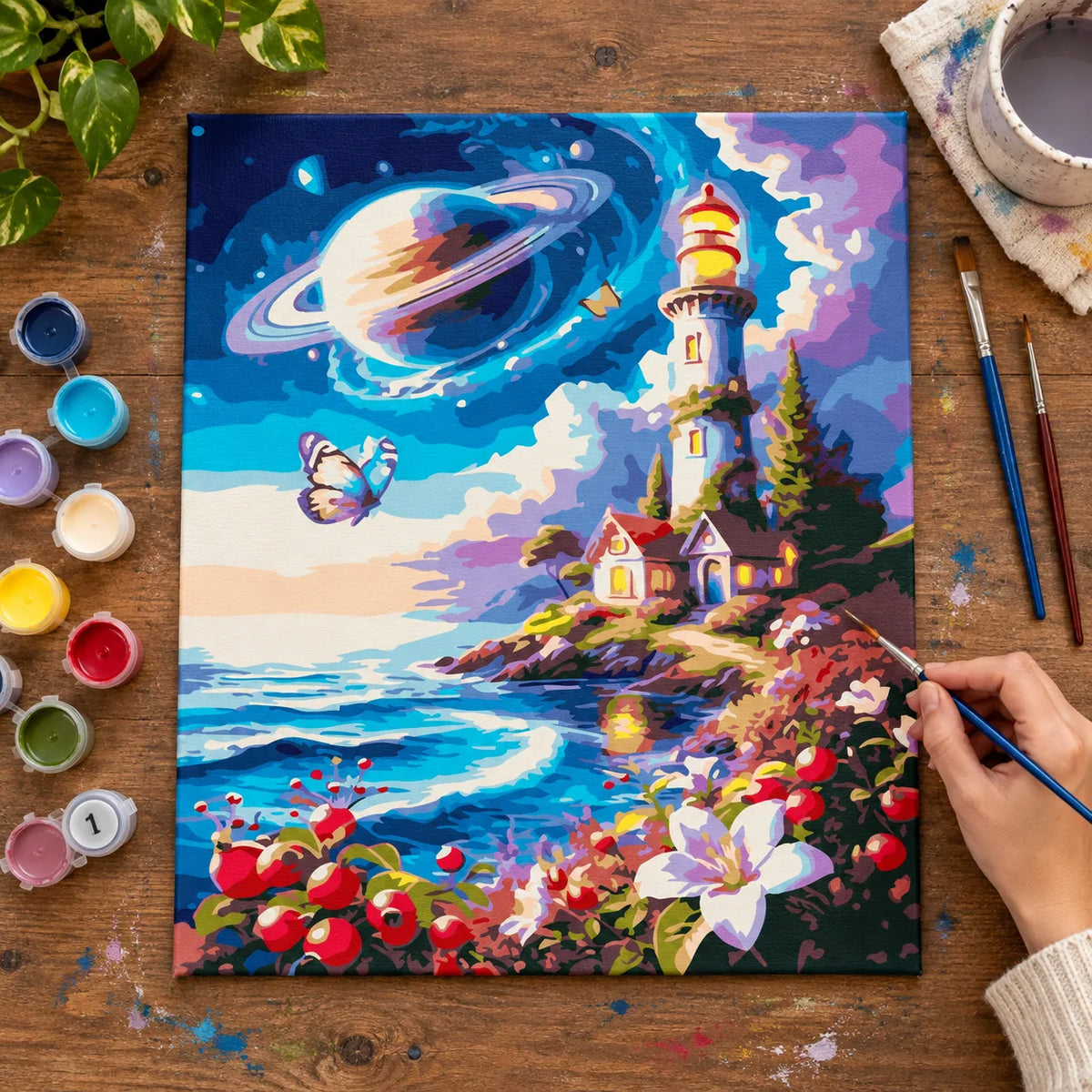 Complete Cosmic Lighthouse and Saturn Sky numbered canvas being painted with acrylic paints and brushes