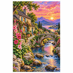 Finished diamond painting of a stone cottage, stream, flowered bridge, and sunset alpine lake on a white background.