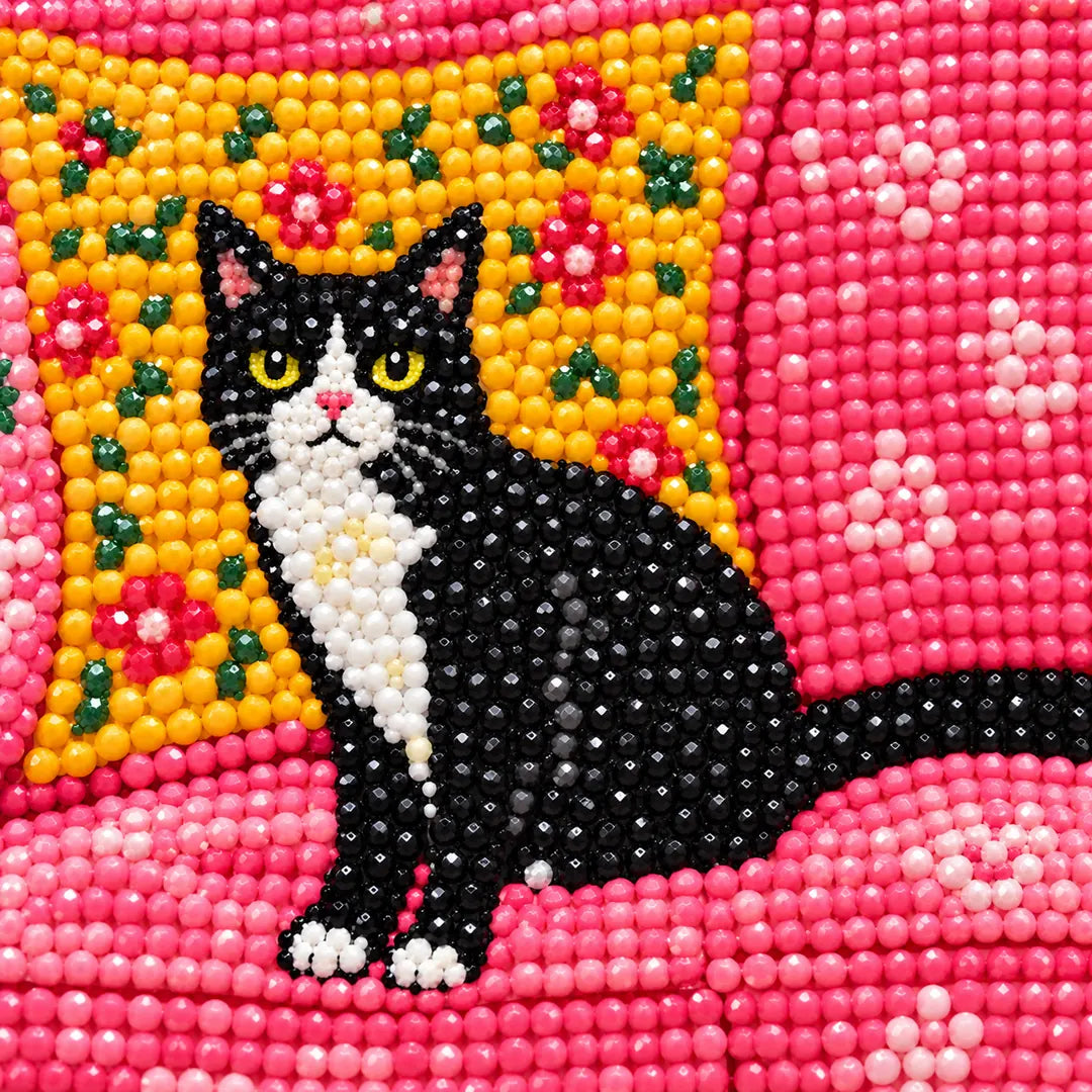 Close-up diamond drill detail of a black cat with colorful floral decor
