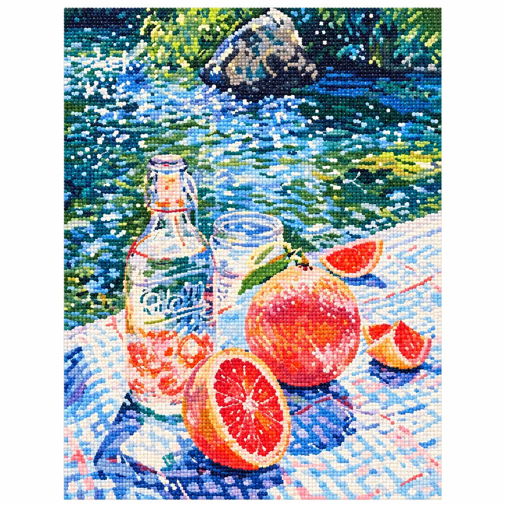 Finished diamond painting of a grapefruit picnic scene beside a flowing river.