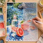 Diamond painting process for a grapefruit picnic scene beside a flowing river.