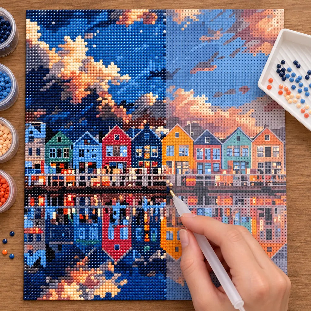 Diamond painting process for Harbor Reflections at Dusk Diamond Painting Kit, with hands applying drills over a colorful harbor houses reflected on calm water at dusk.