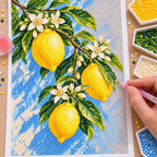 Bright lemons with delicate white blossoms: diamond painting being completed with a pen