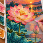 A large pink lotus and closed bud above teal leaves beside a glowing sunset pond: diamond painting in progress with a pen