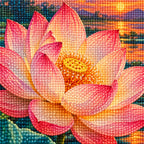 A large pink lotus and closed bud above teal leaves beside a glowing sunset pond: close-up of the diamond drills