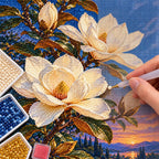 Ivory magnolias beneath a deep blue moonlit sky: diamond painting being completed with a pen
