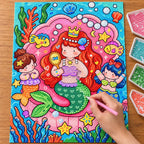Diamond painting process showing mermaid sisters and coral being completed with a stylus