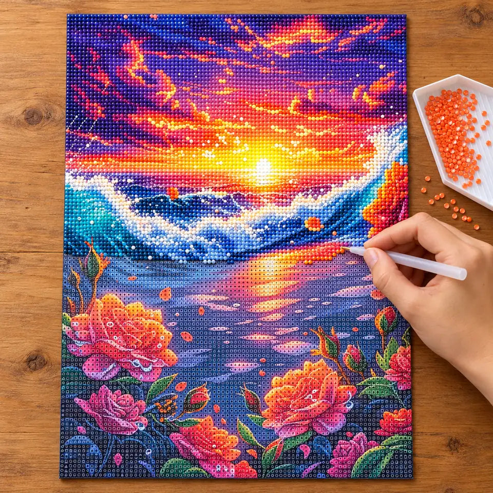 Diamond painting process showing an ocean sunset and roses being completed with a stylus