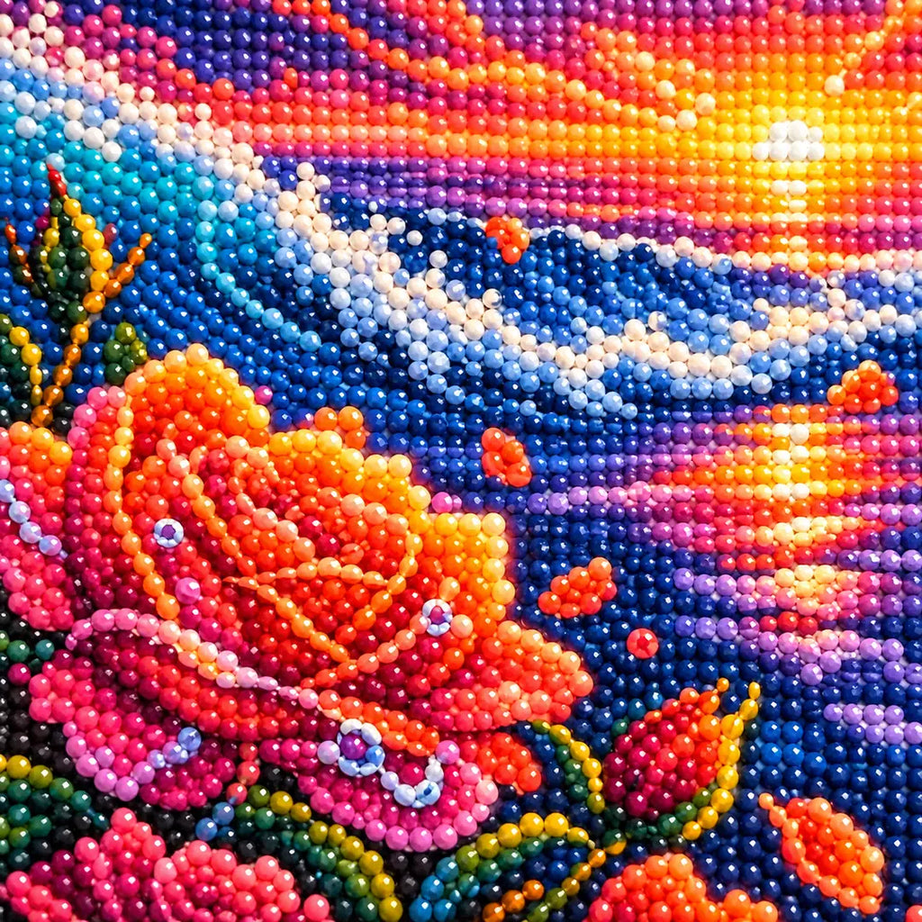 Close-up diamond drill detail of sunset reflections, ocean waves, and rose petals