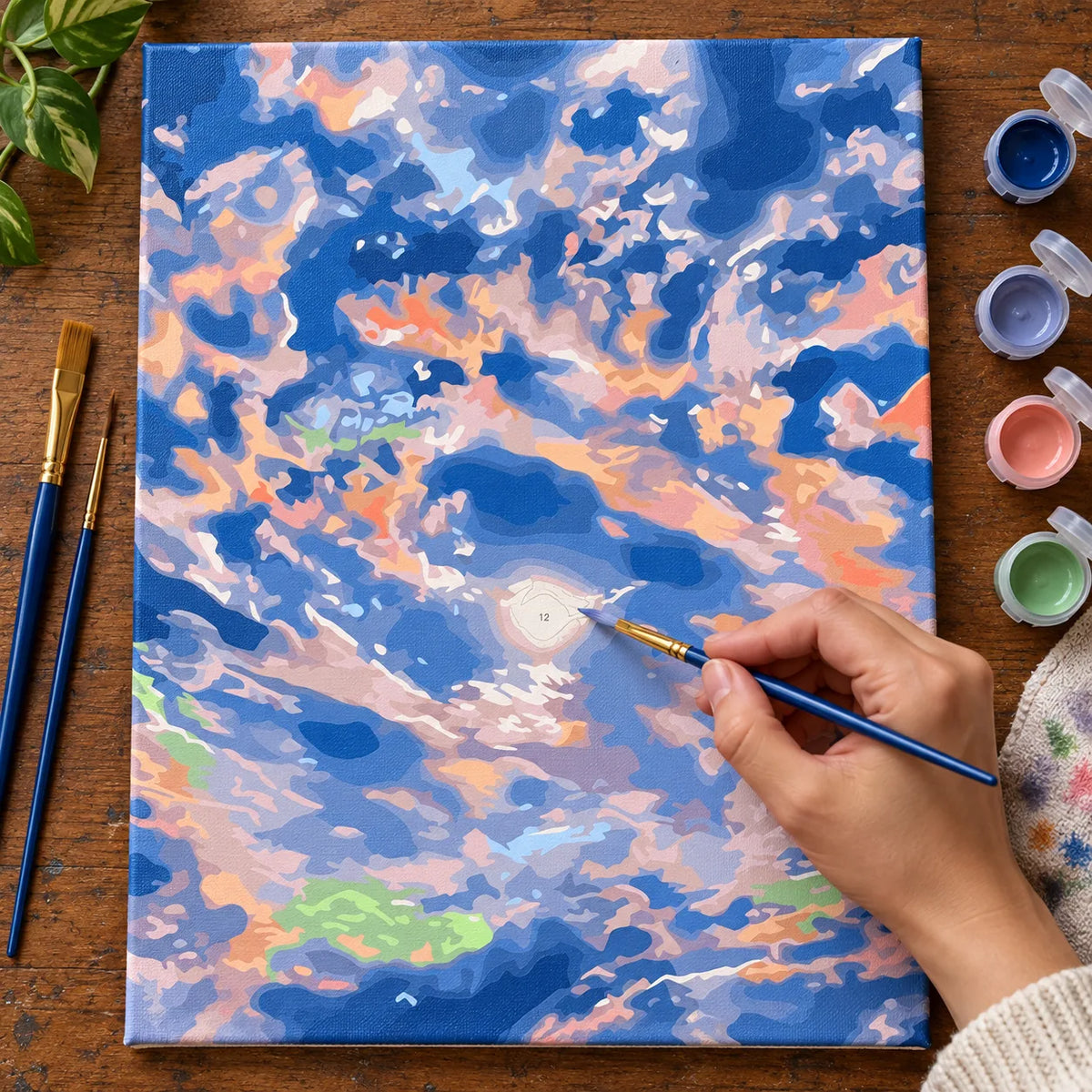Complete Pastel Sunset Clouds numbered canvas being painted with acrylic paints and brushes
