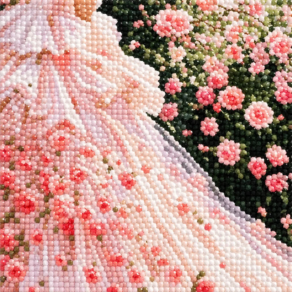 Close-up of diamond drill details in a flowing blush gown surrounded by a rose garden.