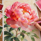 Diamond painting process for Single Pink Peony Diamond Painting Kit, with drills being placed over one full pink peony bloom with green leaves and stems.