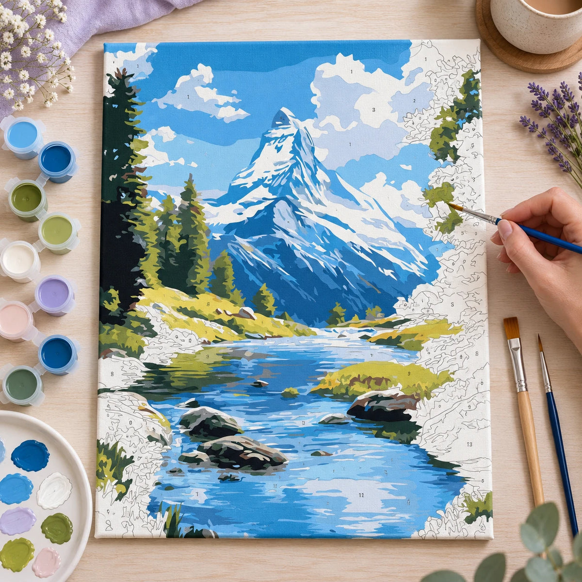 Complete Snowy Mountain River numbered canvas being painted with acrylic paints and brushes