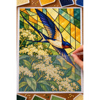Hands placing drills on the stained glass swallow and elderflower diamond painting