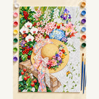 Straw Hat in a Flower Garden Paint by Numbers Kit: complete numbered canvas with paints and brushes arranged for painting
