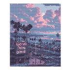 Finished diamond painting for Sunset Over Ocean Drive Diamond Painting Kit, showing a palm-lined coastal street beneath pink and lavender sunset clouds.