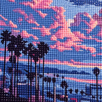 Close-up detail of drill texture across a palm-lined coastal street beneath pink and lavender sunset clouds.