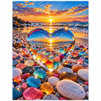 Finished diamond painting for Sunset Through the Crystal Heart Diamond Painting Kit, showing a heart-shaped opening among colorful beach stones framing a glowing sunset.
