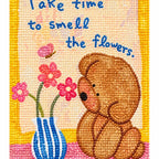 White-background finished diamond painting of a seated brown bear, pink flowers, a striped vase, and the message Take time to smell the flowers