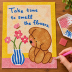 Diamond painting process showing the bear and flower message artwork being completed with a stylus