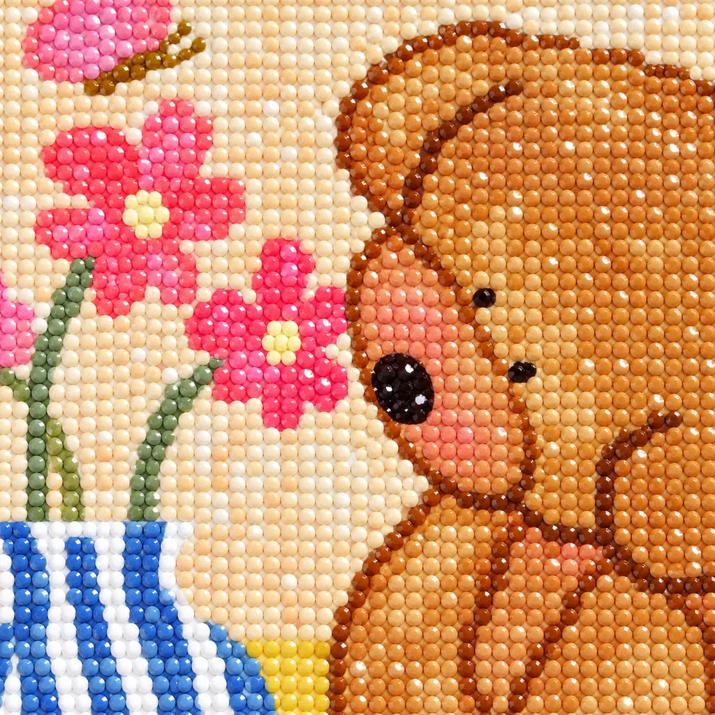 Close-up diamond drill detail of the brown bear, pink blossoms, and striped vase