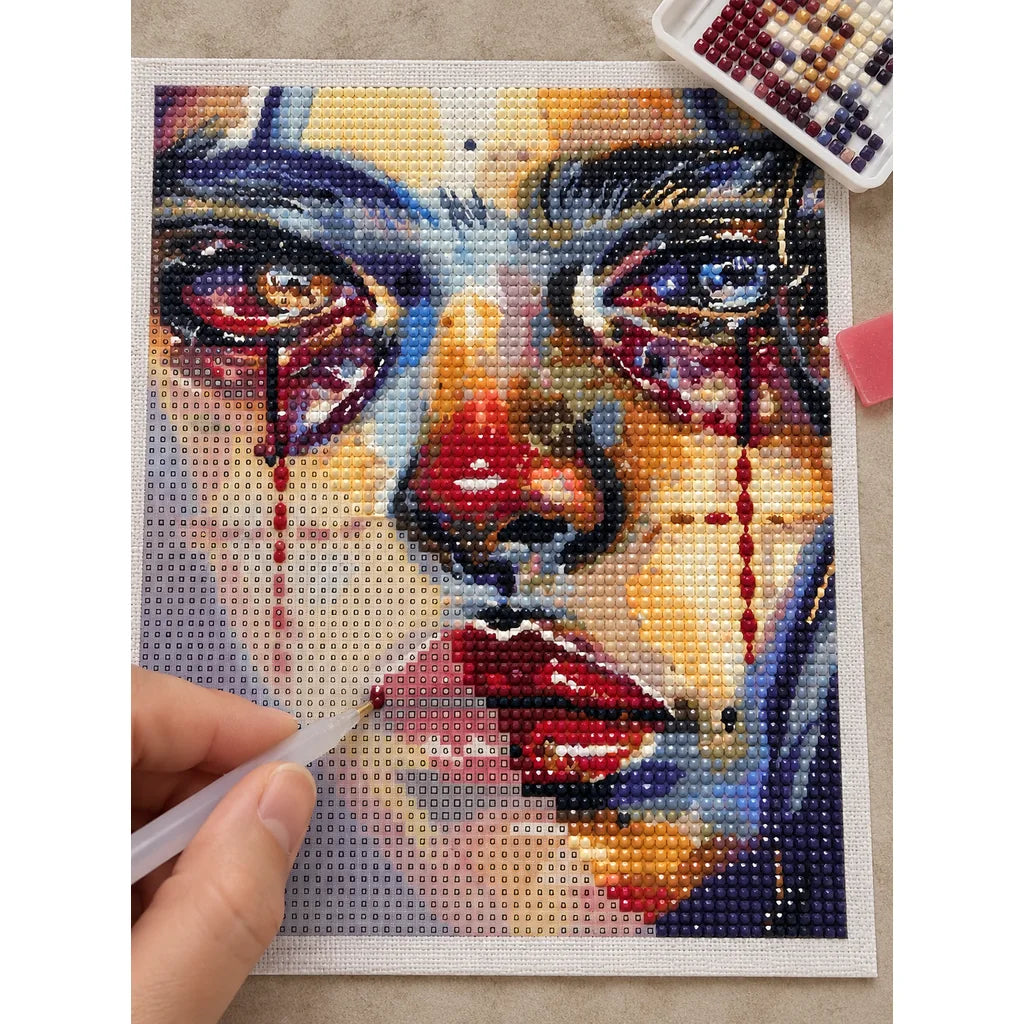 Hands applying diamond drills to a tear-streaked cubist woman portrait.
