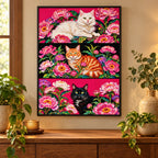Home decor scene featuring the three cat portraits—a white cat, orange tabby, and black cat—among pink peonies diamond painting displayed on a wall.