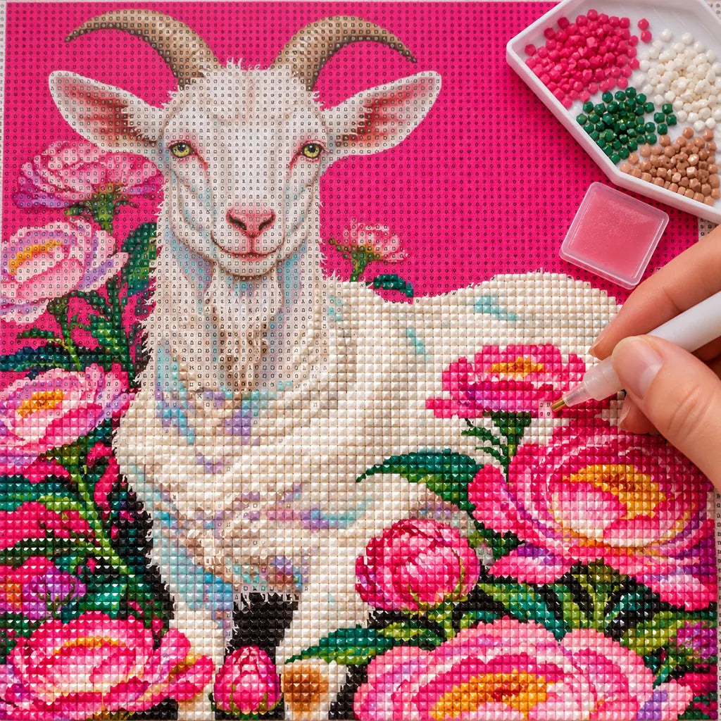 A hand placing drills on a white goat and pink peonies diamond painting canvas
