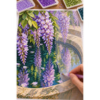 Lavender wisteria and green leaves reflected in a stone basin: diamond painting in progress with a pen