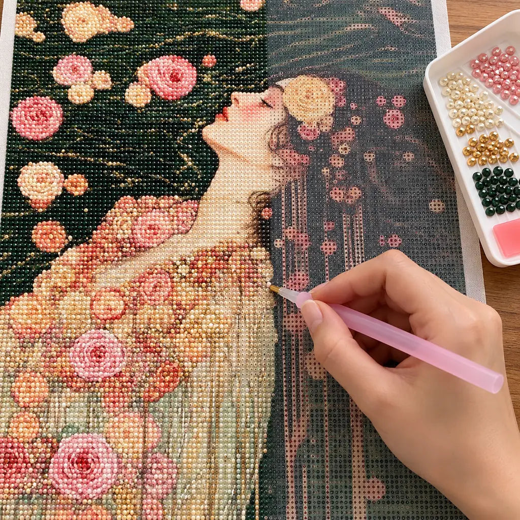 Hands applying drills to a canvas with a woman in a floral gown floating among roses on dark water.