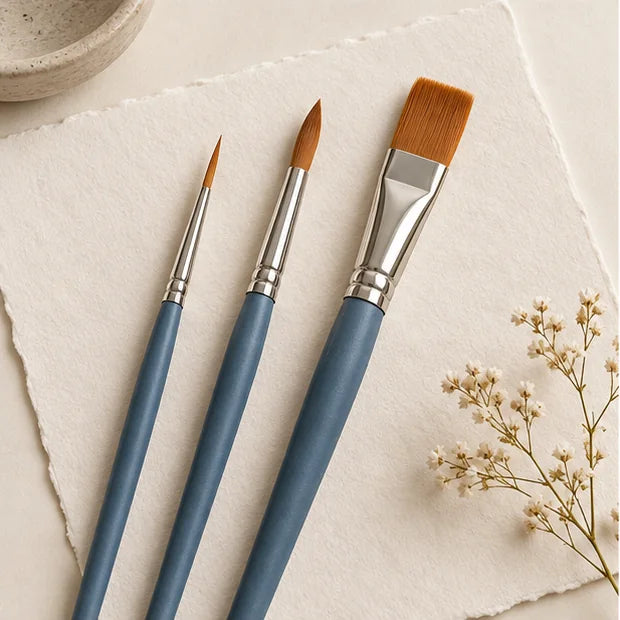 Three paint brushes in fine medium and broad sizes